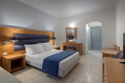 a bedroom with a bed and a desk and a chair at Lydia Maris Resort & Spa in Kolimbia