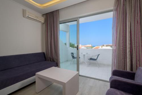 a living room with a couch and a table at Lydia Maris Resort & Spa in Kolimbia