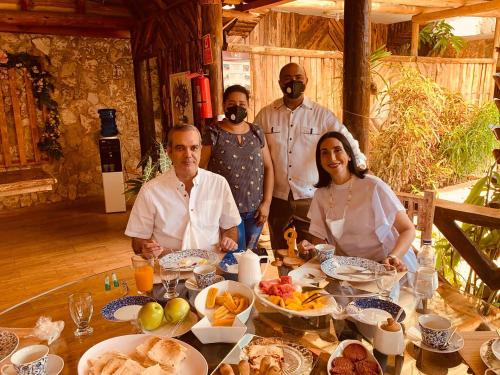 ペデルナレスにあるVista de Águilas Ecolodgeの食べ物を持ってテーブルに座っている人々のグループ