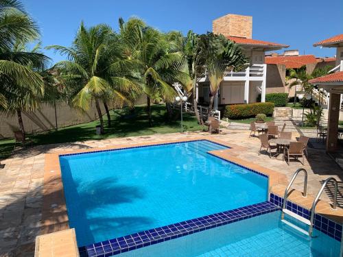 una gran piscina en un patio con palmeras en Pousada Tropical Ilhas en Aquiraz