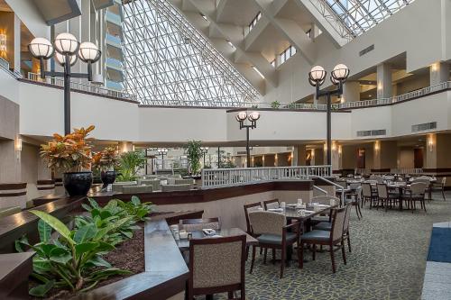 a dining room with tables and chairs in a building at Crowne Plaza Hotel St. Louis Airport, an IHG Hotel in Bridgeton