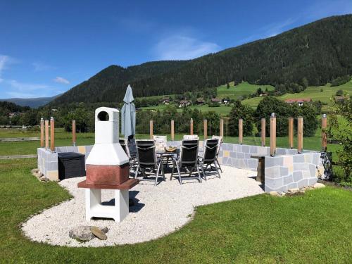 a patio with a table and chairs and an umbrella at Gurkhof Ferienwohnungen in Gnesau