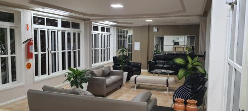 a large living room with couches and chairs at Hotel Pousada Ilha do Mar Bombinhas in Bombinhas