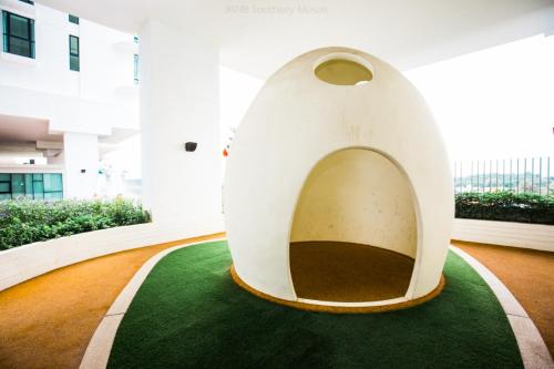 a large white building with a green carpet in a building at Homybed Southkey Mosaic Homestay in Johor Bahru