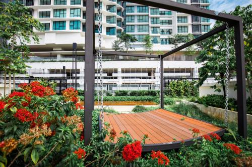 a wooden swing in a garden with flowers at Homybed Southkey Mosaic Homestay in Johor Bahru