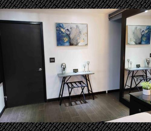 a room with two tables and a black door at The Condo (by Modern Apartments) in Rosarito