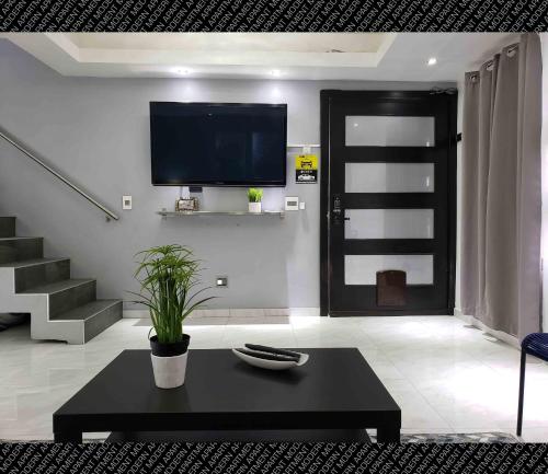 a living room with a tv and a black coffee table at The Condo (by Modern Apartments) in Rosarito