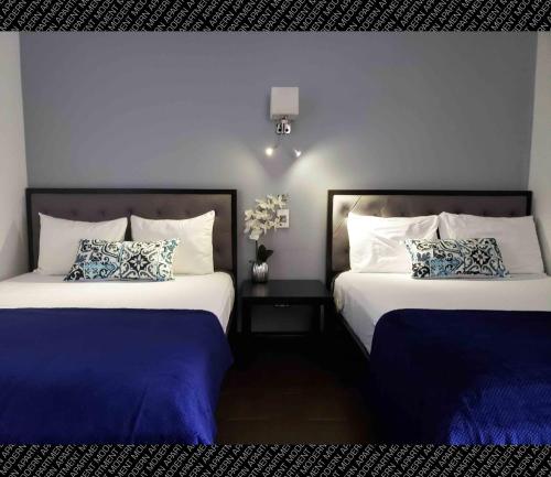 two beds in a hotel room with blue walls at The Condo (by Modern Apartments) in Rosarito