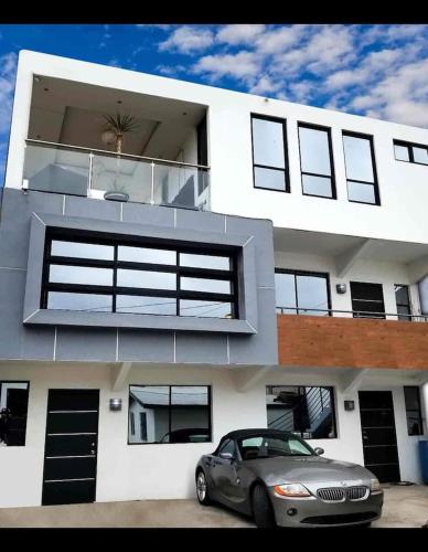 a car parked in front of a white house at The Condo (by Modern Apartments) in Rosarito