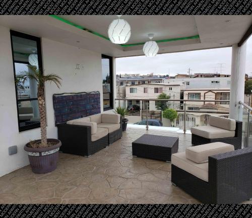 a living room with couches and a palm tree on a balcony at The Condo (by Modern Apartments) in Rosarito