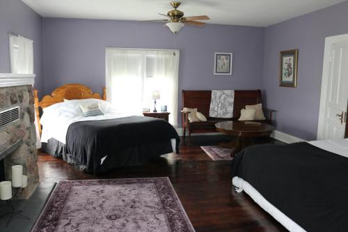 a bedroom with two beds and a chair and a fireplace at LOJ BNB in Morley