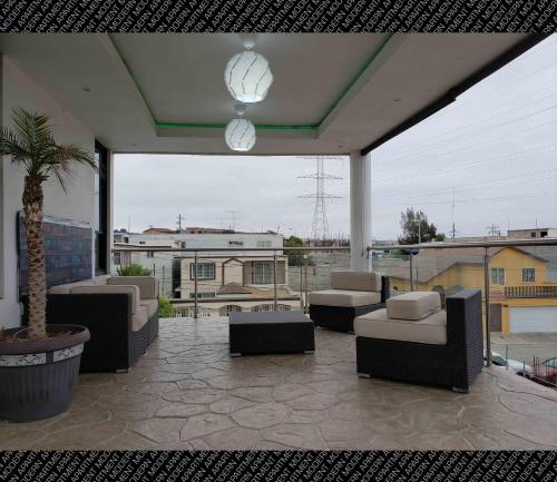 a patio with couches and chairs and a palm tree at The Condo (by Modern Apartments) in Rosarito
