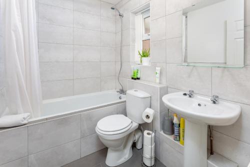 Baño blanco con aseo y lavamanos en The World Famous Henderson House FREE PARKING en Liverpool