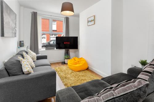 a living room with two couches and a tv at The World Famous Henderson House in Liverpool