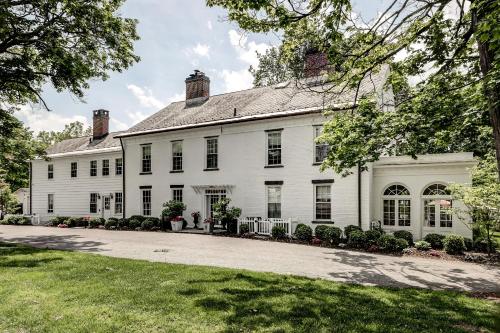 a large white house with a driveway at Stagecoach Inn in Goshen