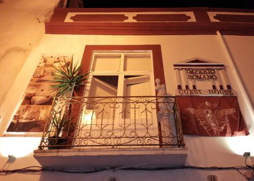 a building with a balcony with a window at Império Romano Guest House in Beja