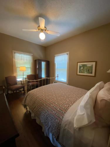 a bedroom with a bed and a ceiling fan at Inn On The River in Glen Rose