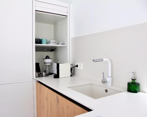 uma cozinha branca com um lavatório e um espelho em Unique, Stylish & Calm El Estanque by the Sea, Adults Only em Costa Teguise