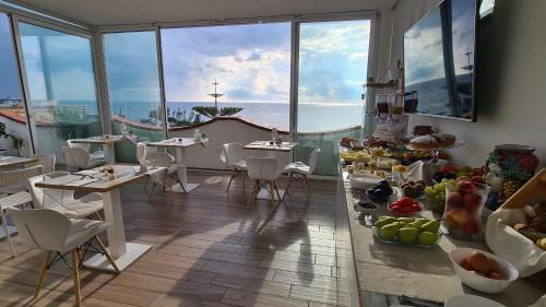 アヴォラにあるPantanello Rooms Avolaのテーブルと椅子が備わり、海の景色を望むレストラン