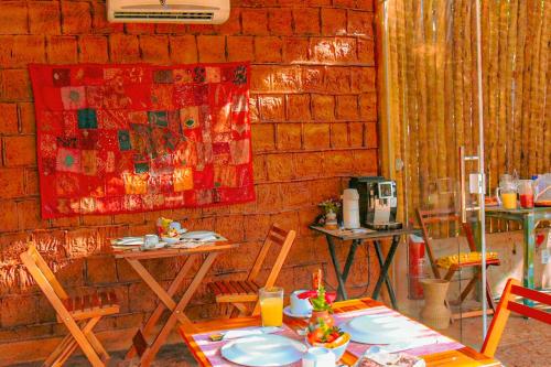 a room with a table and chairs and a wall at Pousada Quinta da Lagoa Azul in Jijoca de Jericoacoara