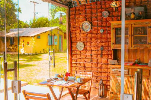 a table and chairs in front of a brick wall at Pousada Quinta da Lagoa Azul in Jijoca de Jericoacoara
