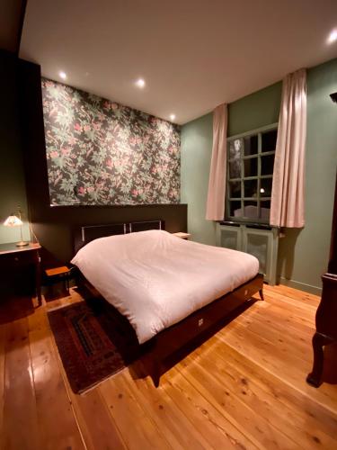 a bedroom with a bed and a large painting on the wall at The Royal Suite II - R.Q.C. in The Hague