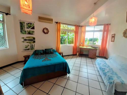 - une chambre avec un lit, un bureau et des fenêtres dans l'établissement TAHITI - Piafau Cottage Pool & View, à Fa'a'ā