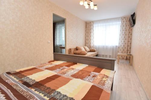a bedroom with a bed with a mirror and a couch at СелимВсех на Куйбышева in Yekaterinburg