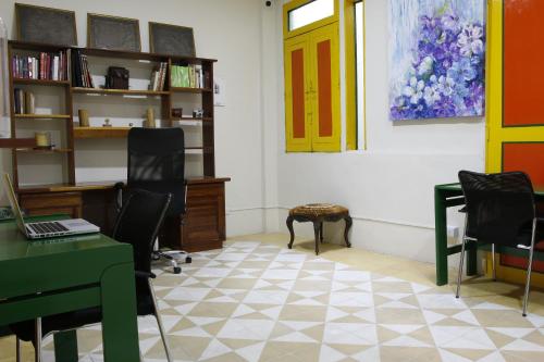 a room with chairs and a desk with a laptop at Golden Frog Manizales in Manizales