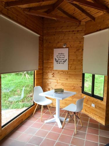 a dining room with a table and two chairs at Altozano Cabañas in Guatavita