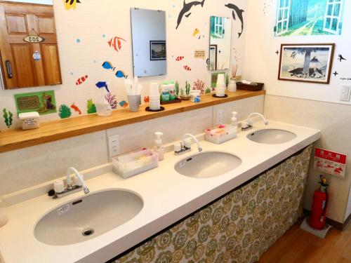 een badkamer met 2 wastafels en 2 spiegels bij ホステル富士山 結 in Fujiyoshida