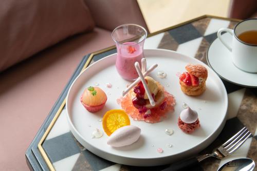 a plate of desserts on a table with a drink at Hyatt Centric Kanazawa in Kanazawa