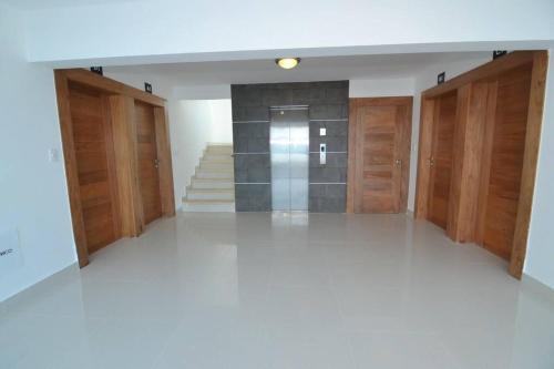 a hallway with wooden doors and stairs in a building at Torre Real IV L3 Santiago DR con cocinero para desayuno in Santiago de los Caballeros