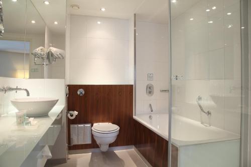 a bathroom with a toilet and a sink and a shower at Holiday Inn London Camden Lock by IHG in London