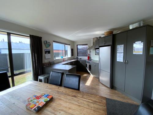 a kitchen with a table and chairs and a kitchen with a refrigerator at Anglers Retreat in Lake Tekapo