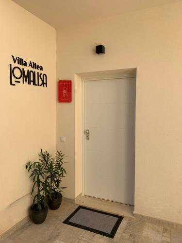 a white door in a room with two plants at Villa Altea Lomalisa in Altea