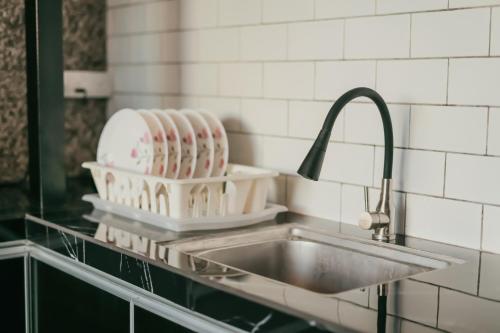 a kitchen sink with dishes on a counter at The Luxury Villa -Private Pool- in Pantai Cenang