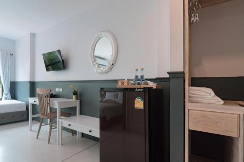 a kitchen with a black refrigerator in a room at Chanita Hotel Chumphon in Chumphon