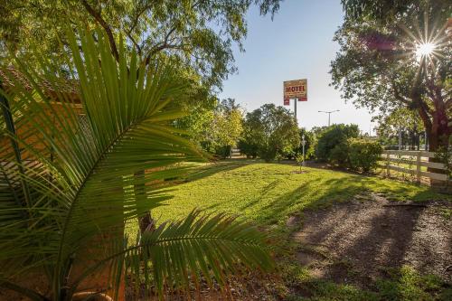 a grassy area with trees and a street sign at Manera Heights Apartments in Dubbo