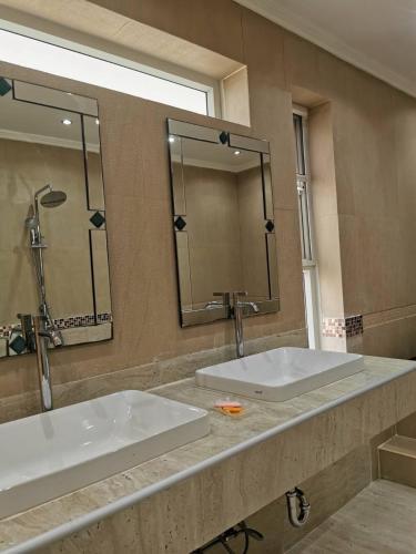 a bathroom with two sinks and a large mirror at PX POOL VILLA PATTAYA in Nong Prue