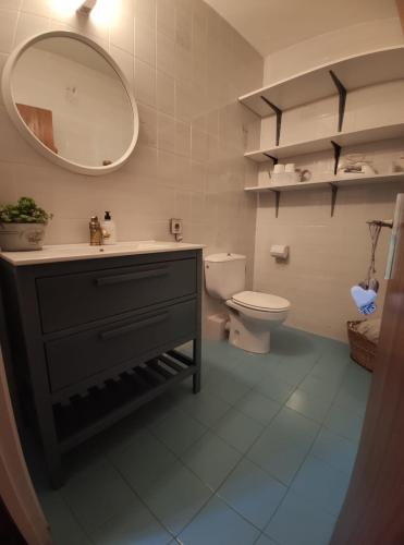 a bathroom with a sink and a toilet and a mirror at Apartamento Capelot in Jaca