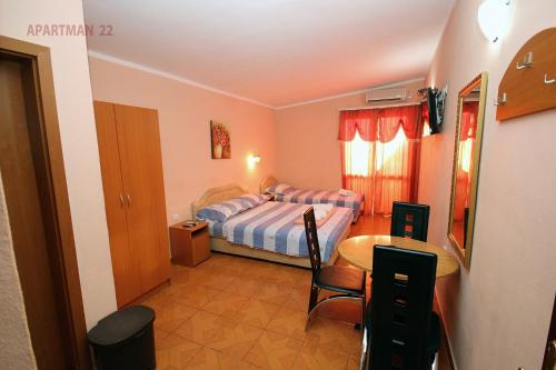 a bedroom with a bed and a table in it at Apartments Kojic in Bar