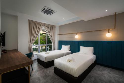 北赖Masson Hotel Butterworth的有两张床和一张书桌的酒店房间