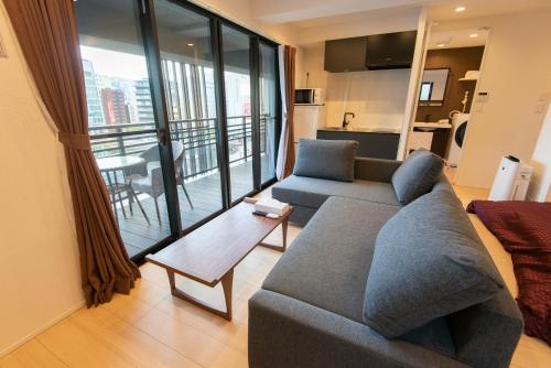 ein Wohnzimmer mit Couch und großem Fenster in der Unterkunft MK Hotels Nishinakasu in Fukuoka