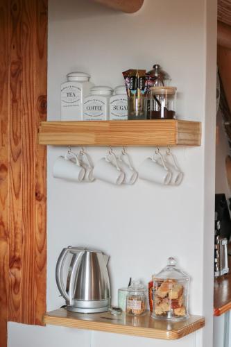 a kitchen with wooden shelves with pots and pans at The House of Braganza in Kommetjie
