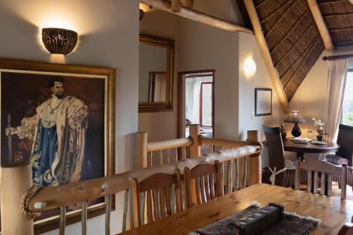 a dining room with a painting of a man on the wall at The House of Braganza in Kommetjie