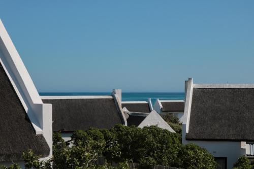 a row of houses with the ocean in the background at The House of Braganza in Kommetjie