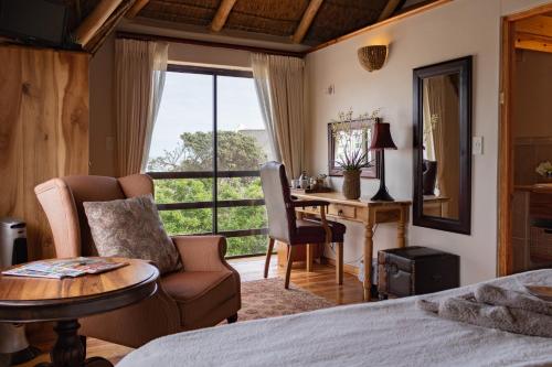 a bedroom with a bed and a table and a desk at The House of Braganza in Kommetjie