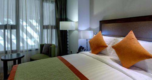 a hotel room with a bed with orange pillows at Crowne Plaza Madinah by IHG in Al Madinah