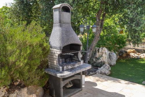 a stone oven is sitting in a garden at Lev Hahoresh Boutique Hotel in Shomera